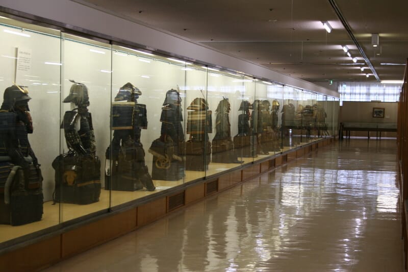 Row of Japanese samurai armours displayed in an aisle of the Watanabe Art Museum, Tottori
